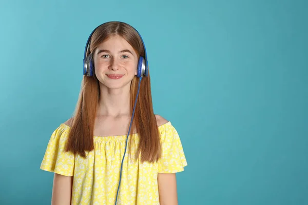 Adolescente disfrutando de la música en los auriculares en el fondo de color. Espacio para texto —  Fotos de Stock