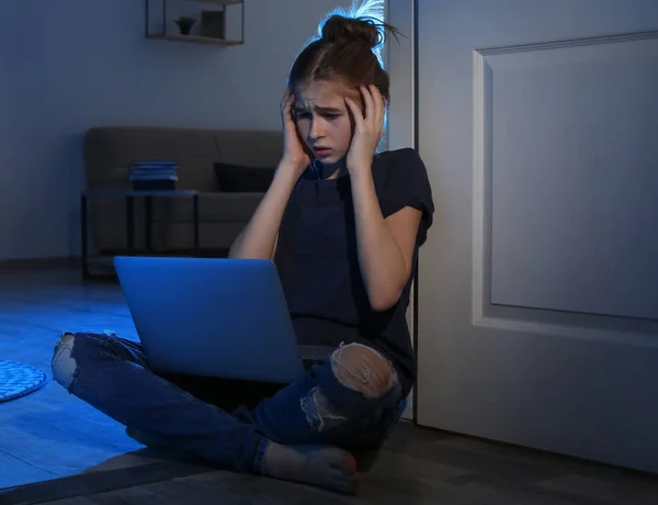 Doodsbang tiener meisje met laptop op de vloer in donkere kamer. Gevaar van Internet — Stockfoto