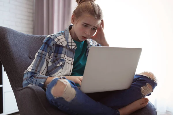 Menina adolescente chocado com laptop dentro de casa. Perigo da internet — Fotografia de Stock