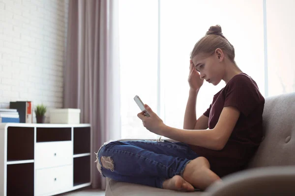 Zdenerwowany nastoletnią dziewczynę z smartphone w pokoju. Niebezpieczeństwo Internetu — Zdjęcie stockowe