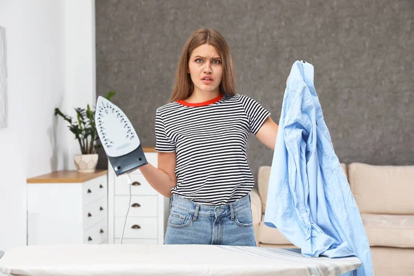 Emotionale Frau mit Bügeleisen und Hemd zu Hause — Stockfoto