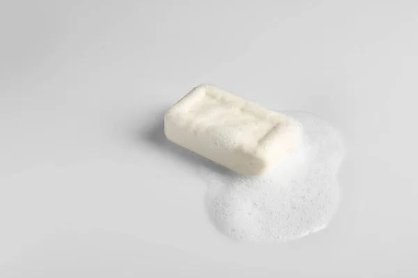 Soap bar and foam on white background — Stock Photo, Image