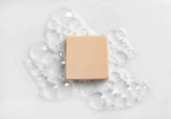 Soap bar and foam on white background, top view. Mockup for design — Stock Photo, Image