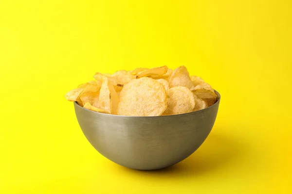 Heerlijke knapperige aardappelchips in schaal op kleur achtergrond — Stockfoto