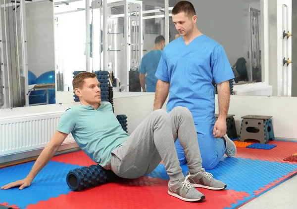 Patient exercising under physiotherapist supervision in rehabilitation center — Stock Photo, Image