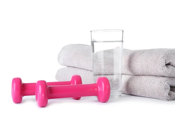 Stylowe hantle, szklanka wody i ręczniki na białym tle. Fitness w domu — Zdjęcie stockowe