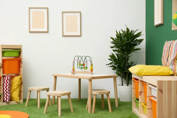 Stilvolles Spielzimmer-Interieur mit Tisch und Hockern — Stockfoto