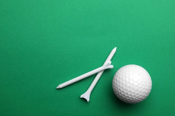 Bola de golfe e tees sobre fundo de cor, flat lay. Espaço para texto — Fotografia de Stock