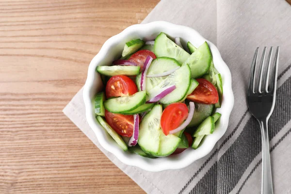 Schüssel mit leckerem Gurkentomatensalat auf Holztisch serviert, flach gelegt — Stockfoto