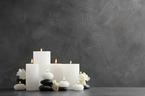 Beautiful composition with lit candles and flowers on table. Space for text — Stock Photo, Image