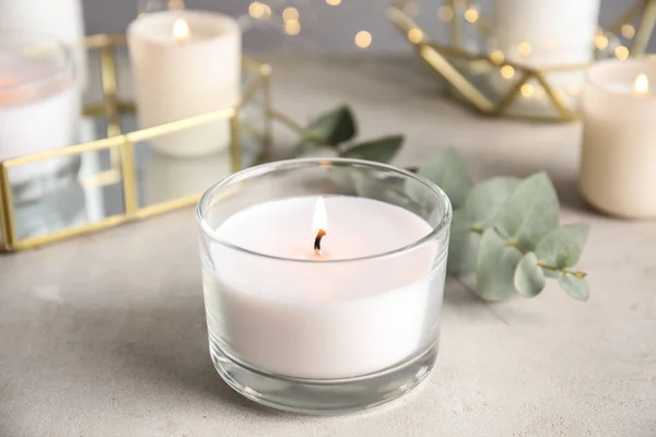 Спалювання ароматичної свічки та гілки евкаліпта на столі — стокове фото