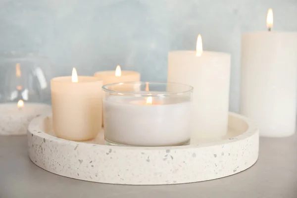 Bandeja con velas aromáticas ardientes en la mesa —  Fotos de Stock
