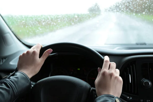 Woman driving car on rainy day, closeup of hands — 스톡 사진