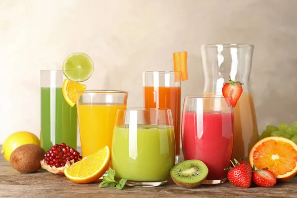 Glasvaror med olika juicer och färsk frukt på bordet — Stockfoto