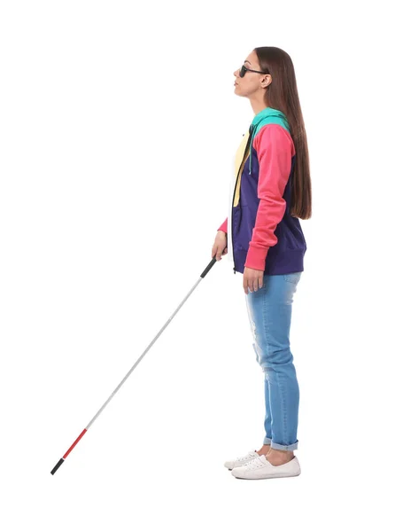 Young blind person with long cane walking on white background — Stok fotoğraf