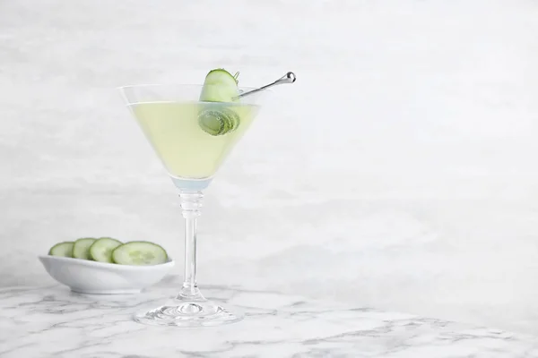 Vaso de martini con pepino sobre mesa de mármol sobre fondo claro. Espacio para texto — Foto de Stock