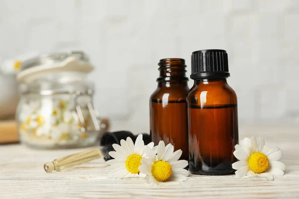 Composición con botellas de aceite esencial de manzanilla sobre la mesa. Espacio para texto — Foto de Stock