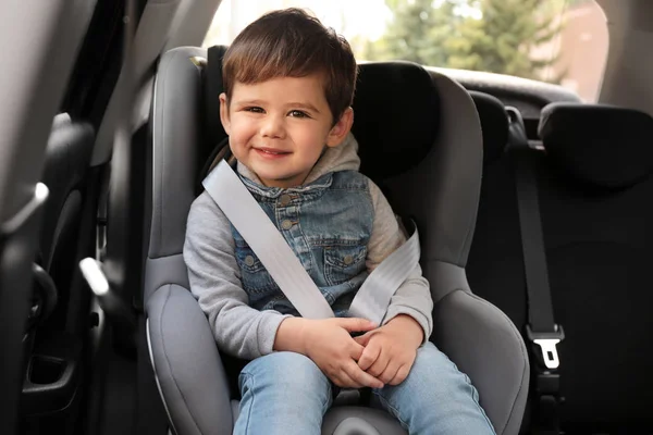 Nettes kleines Kind, das im Sicherheitssitz im Auto sitzt. Gefahrenabwehr — Stockfoto