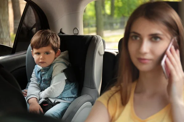 어머니는 뒷좌석에 아들과 함께 차를 운전하는 동안 전화로 이야기. 위험에 처한 어린이 — 스톡 사진