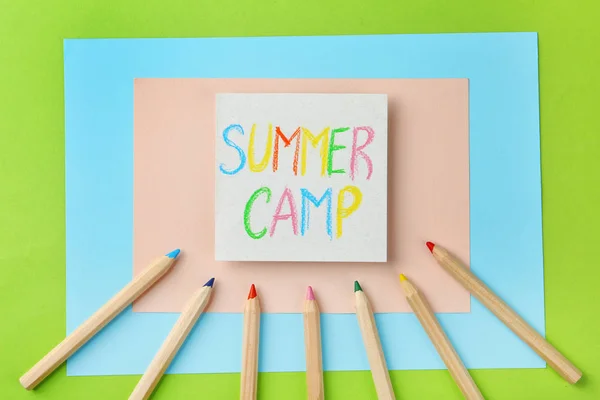 Papel com texto escrito SUMMER CAMP e diferentes lápis sobre fundo de cor, flat lay — Fotografia de Stock