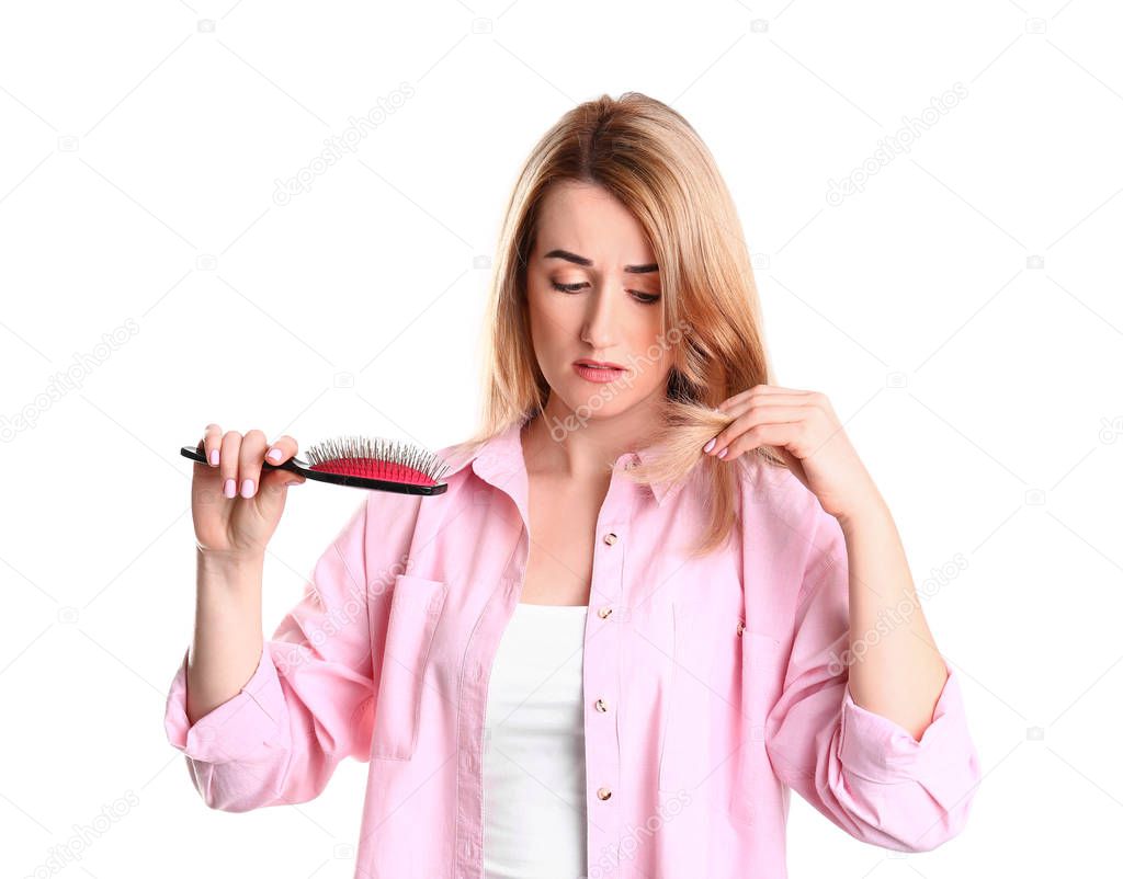 Young woman brushing hair against white background