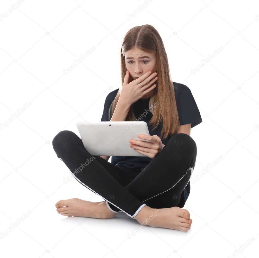 Shocked teenage girl with tablet on white background. Danger of internet