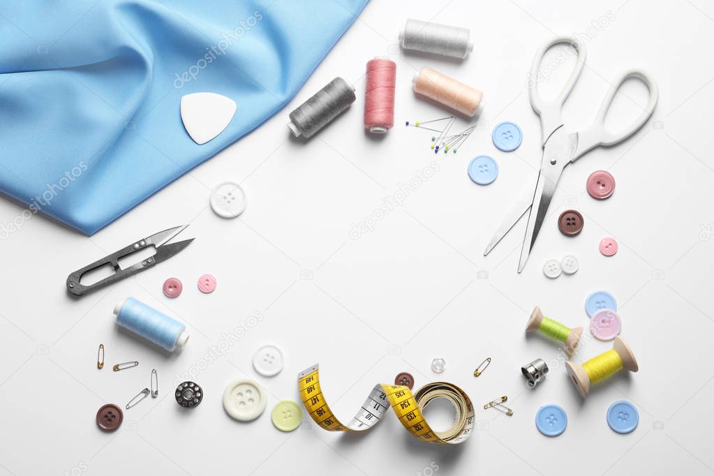 Flat lay composition with scissors and sewing supplies on white background. Space for text