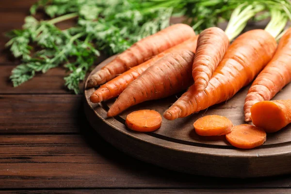 Styrelse med färska morötter på trä bakgrund, närbild. Utrymme för text — Stockfoto