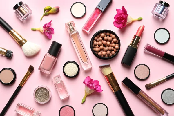 Olika makeup produkter med blommor på färg bakgrund — Stockfoto