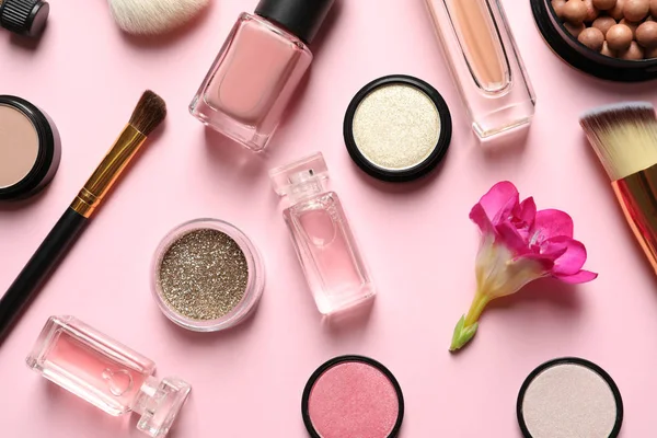 Olika makeup produkter med blommor på färg bakgrund — Stockfoto