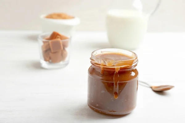 Jar of tasty caramel sauce on table, closeup. Space for text — Stock Photo, Image