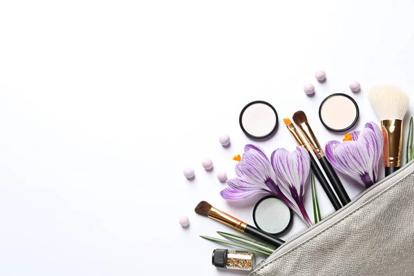 Make-up producten, bloemen en cosmetische tas op witte achtergrond, bovenaanzicht — Stockfoto