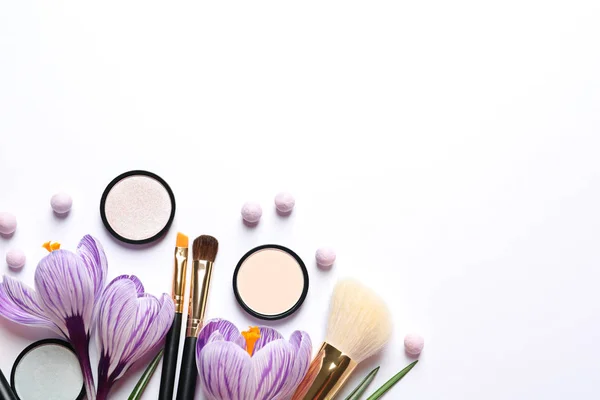 Verschillende make-up producten en bloemen op witte achtergrond, bovenaanzicht — Stockfoto