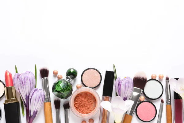 Verschillende make-up producten en bloemen op witte achtergrond, bovenaanzicht — Stockfoto