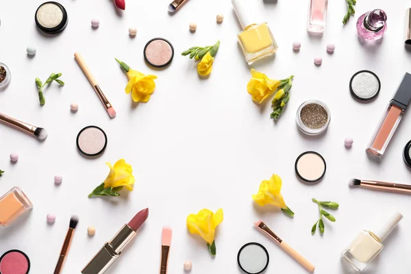 Different makeup products and flowers on white background, top view with space for text — Stock Photo, Image