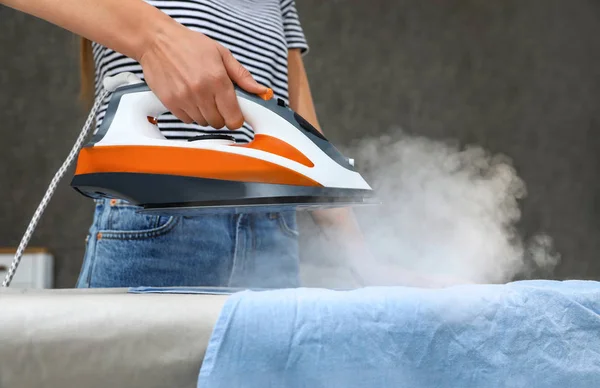 Mujer joven planchando ropa a bordo en casa, primer plano — Foto de Stock