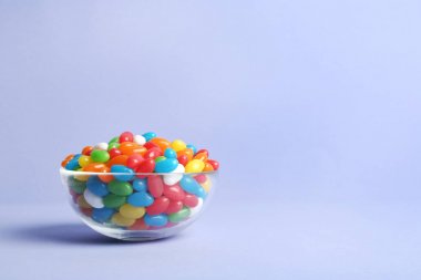 Renk arka planda lezzetli parlak jöle fasulye ile Cam kase