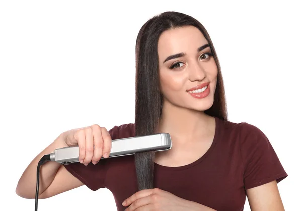 Šťastná žena používající vlasní železo na bílém pozadí — Stock fotografie