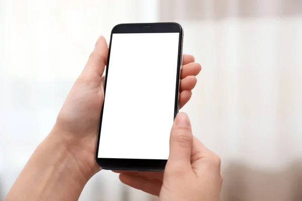 Woman Holding smartphone met leeg scherm op wazige achtergrond, close-up van de handen. Ruimte voor tekst — Stockfoto