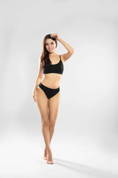 Full längd porträtt av attraktiv ung kvinna med smal kropp i badkläder på vit bakgrund — Stockfoto