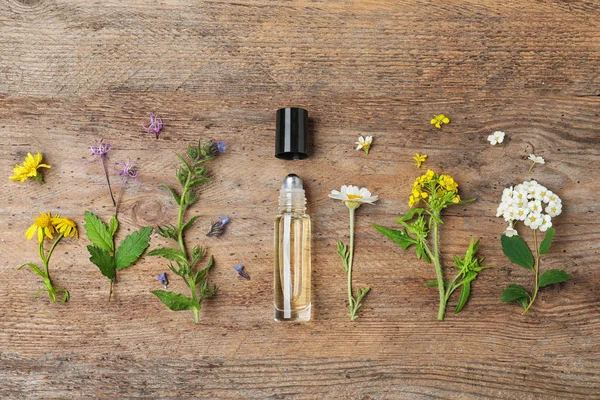 Plat lag samenstelling met etherische olie en bloemen op houten tafel — Stockfoto