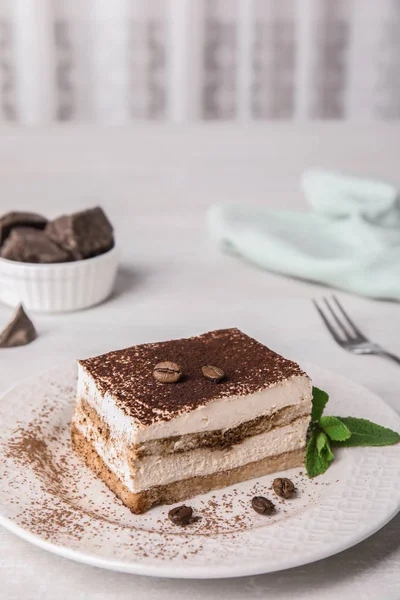 Tiramisu cake with coffee beans on table — Stock Photo, Image