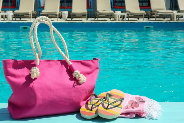 Accesorios de playa en cubierta de madera cerca de la piscina. Espacio para texto —  Fotos de Stock