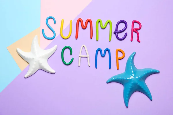 Texto SUMMER CAMP feito de modelagem de argila e estrelas-do-mar decorativas sobre fundo de cor, flat lay — Fotografia de Stock