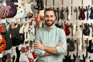 Müzik mağazasında gitar yakın genç dükkan asistanı