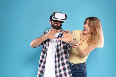 Genç adam VR kulaklık ve renk arka plan üzerinde duygusal kadın ile video oyunları oynuyor