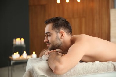 Spa salonunda masaj masasında rahatlatıcı yakışıklı adam