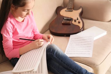 Evde müzik notları yazma gitar ile küçük kız
