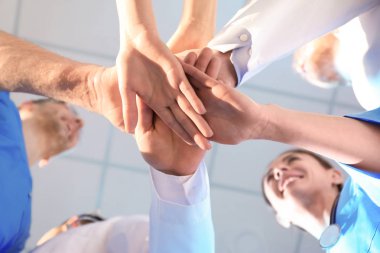 Genç tıp doktorları iç mekana, alt görünüme el koyuyorlar. Birlik konsepti