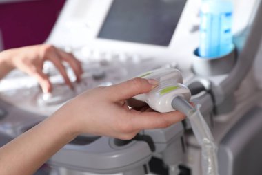 Sonographer klinikte ultrason makinesi sondası tutan, closeup